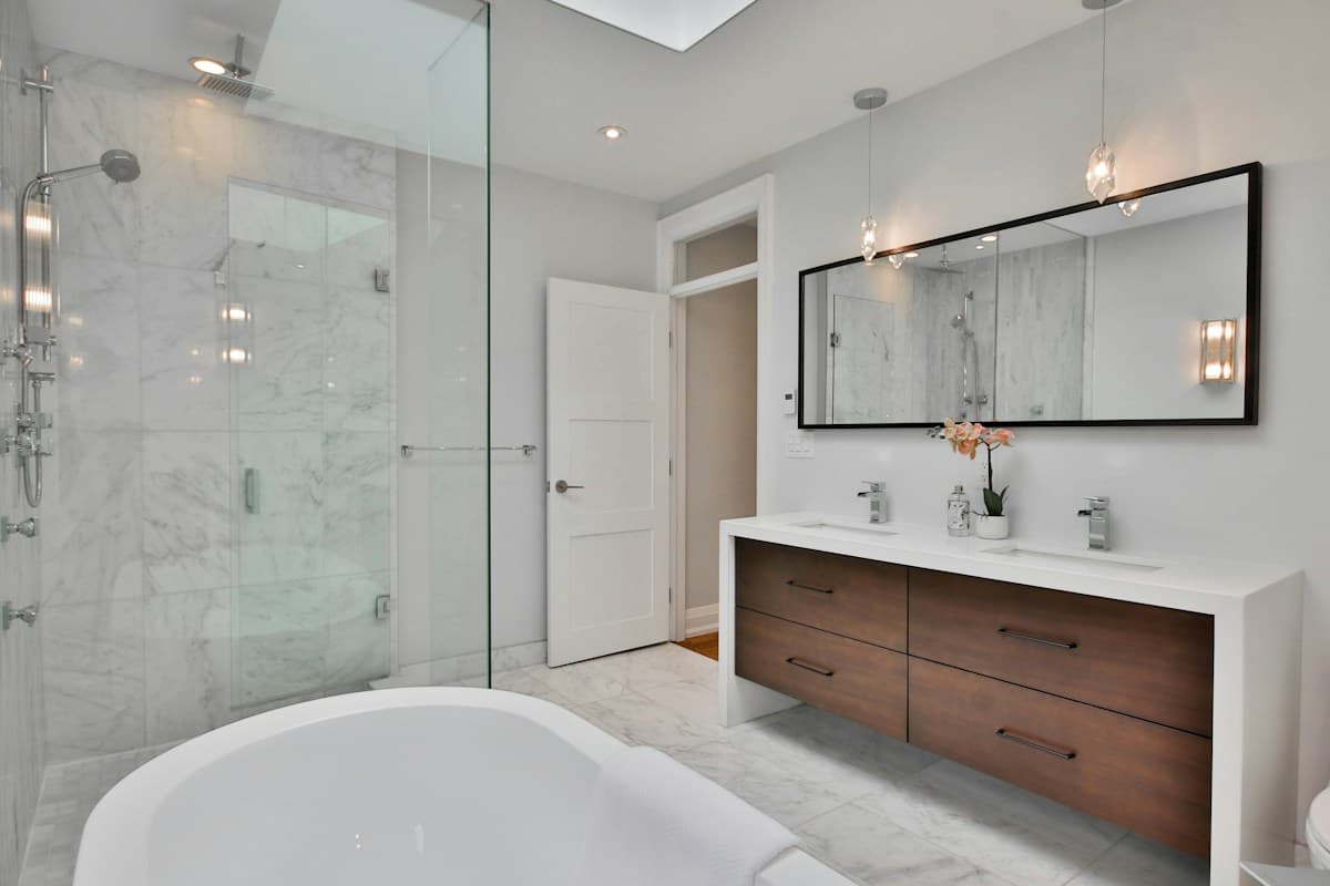 Salle de bains en marbre blanc avec baignoire et douche