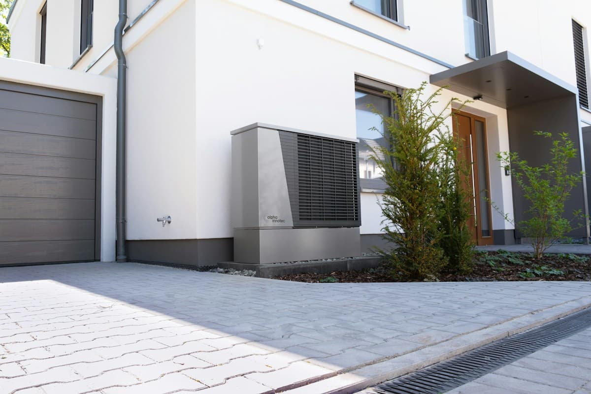 Maison blanche équipée d'une pompe à chaleur extérieure